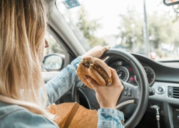 É permitido comer ou beber enquanto conduz? O que diz a lei e quando pode ser multado