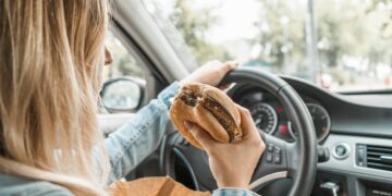 É permitido comer ou beber enquanto conduz? O que diz a lei e quando pode ser multado